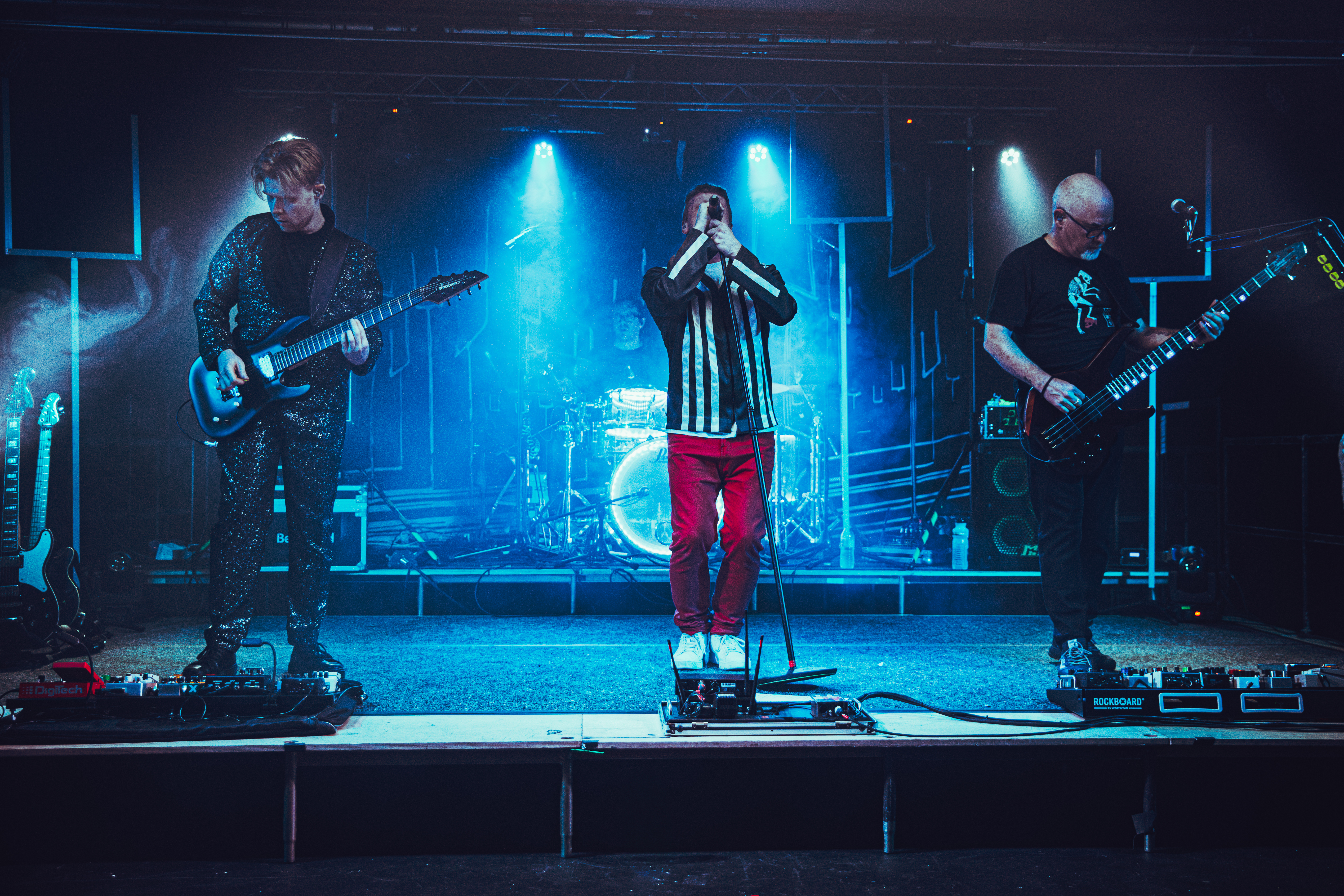 BEMUSED performing live on stage with dramatic blue and red lighting